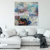 colorful abstract painting on wall above white couch
